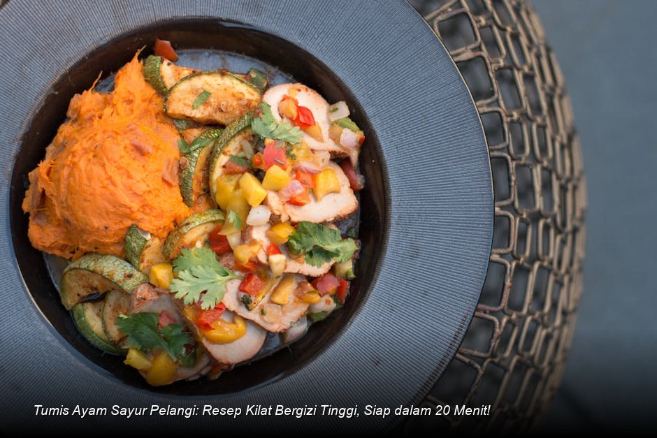 Semangkuk penuh Tumis Ayam Sayur Pelangi dengan potongan ayam dan aneka sayuran berwarna cerah, disajikan dengan taburan biji wijen sangrai.