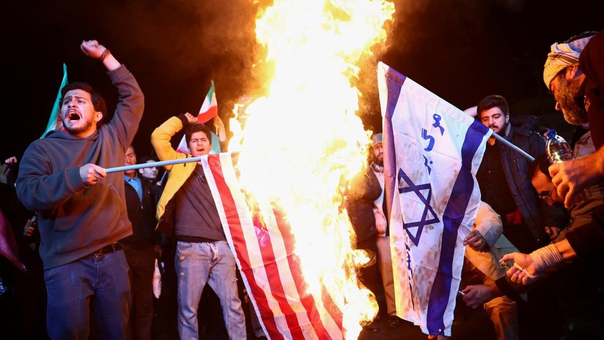 Foto: Orang-orang membakar bendera AS dan Israel, saat mereka berkumpul setelah gencatan senjata selama dua minggu dalam perang Iran diumumkan, di Teheran, Iran, 8 April 2026. (via REUTERS/Majid-Asgaripour)