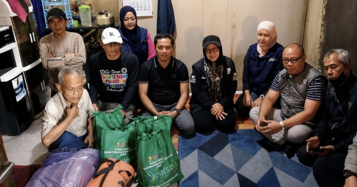 PEDULI WARGA: Camat Majalaya H. Rofiran (tengah) bersama jajaran Pemerintah Kabupaten Bandung, Dinas Sosial, Dinas Kesehatan, Disperkimtan, Puskesmas Wangisagara, dan Pemerintah Desa Sukamukti menyerahkan bantuan sosial berupa paket sembako dan family kit kepada warga yang sedang sakit di Kampung Rancawaas RW 12, Desa Sukamukti, Kecamatan Majalaya, Minggu (5/7/2026).