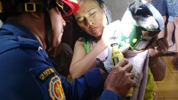 Petugas Damkar berusaha mengevakuasi kaleng biskuit yang nyangkut di kepala balita. (Foto: Dok. Damkar Ciamis)